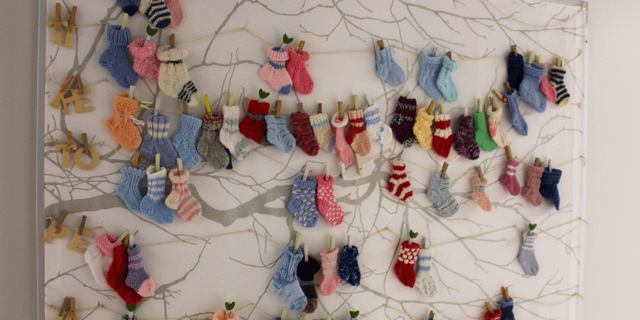Tyksin synnytyssairaalan seinäkalenteri, jossa jokainen sukka kuvaa yhtä syntynyttä vauvaa.