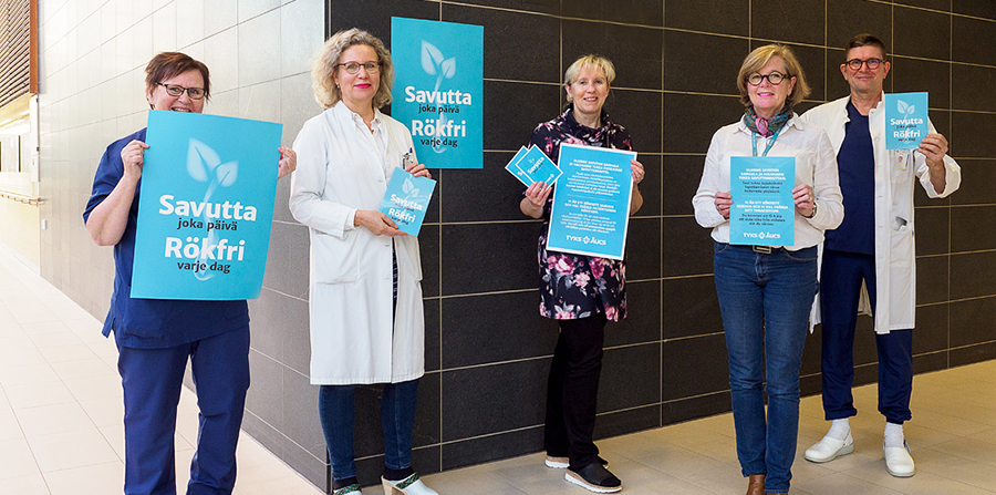 Fem personer står i korridoren på sjukhuset och håller affischer och broschyrer från Rökfri varje dag -kampanjen.
