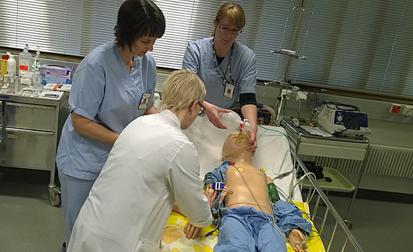 Kolme hoitajaa harjoittelevat pienten lasten hoitoa simulaationukella.