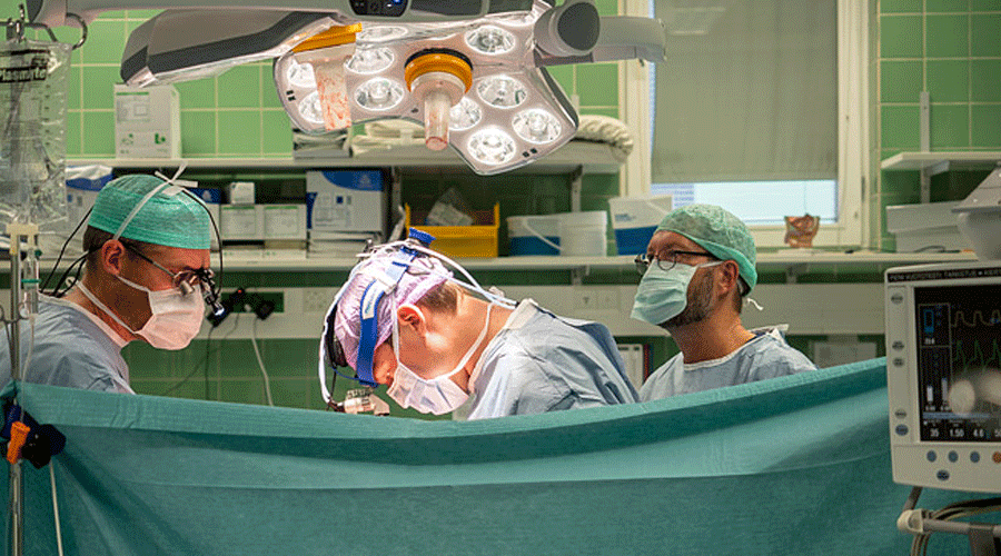Kolme urologian lääkäriä leikkaussalissa