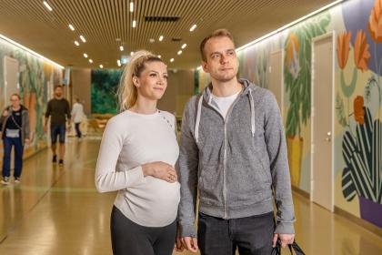 A pregnant woman and a man in the hallway of the Lighthouse hospital.