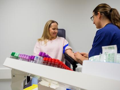 Sjukskötare tar ett blodprov från en kvinna.