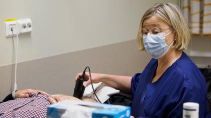 Sairaanhoitaja tekee virtsarakon ultraäänitutkimusta potilaalle. 