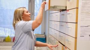 Sairaanhoitaja etsii lääkettä osaston lääkehuoneen laatikoista. 