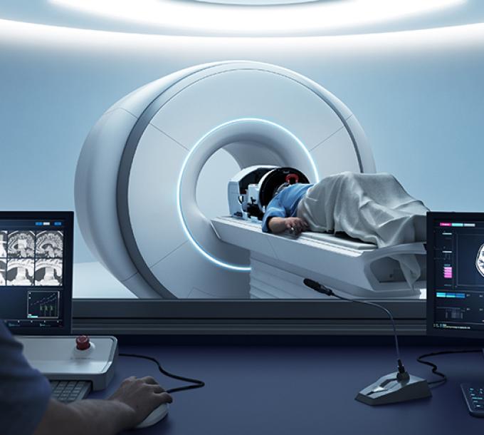 Patient lies in the MRI machine with the Neuro-HIFU machine.
