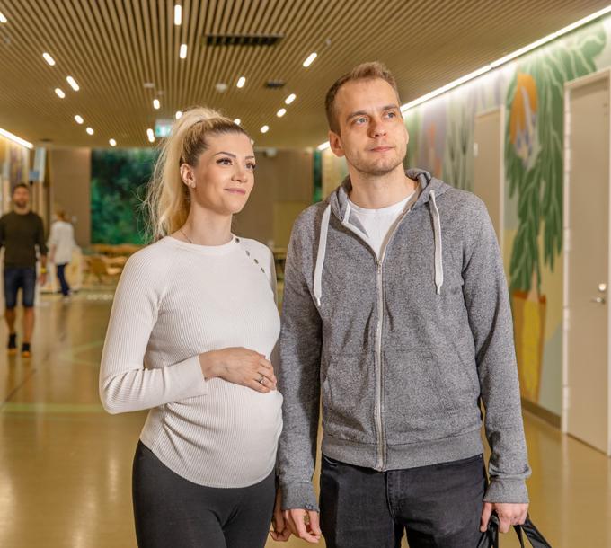 A pregnant woman and a man in the hallway of the Lighthouse hospital.