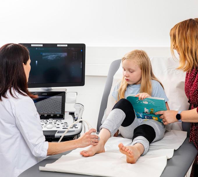 Lääkäri kuvaa lapsen nilkkaa ultraäänellä.