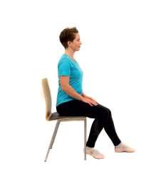 nainen istuu tuolilla polvi koukussa.