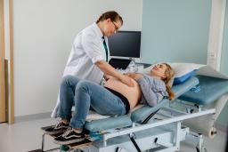 Lääkäri palpoi raskaana olevaan potilaan vatsaa.